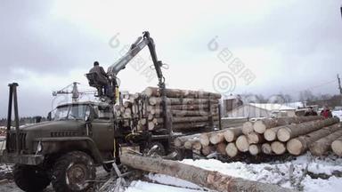 重型爪式装载机从锯木厂的重型<strong>卡车上</strong>卸下原木